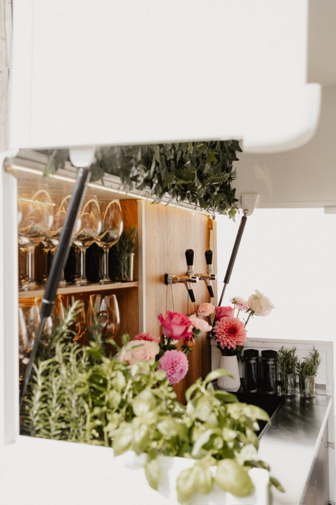 Theke der Ape Bar mit Zapfhähnen und Blumen